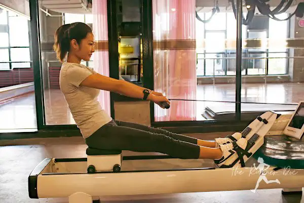 woman on water rowing machine to help prevent run injury